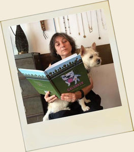 Woman reading Galunker - The illustrated book starring a pitbull, with a dog in her lap